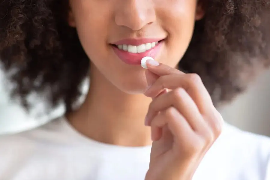 Woman with an afro about to take a pill