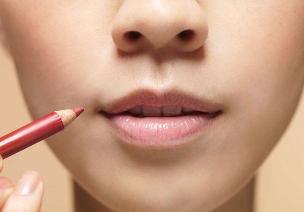 Applying lip liner to enhance natural lips.